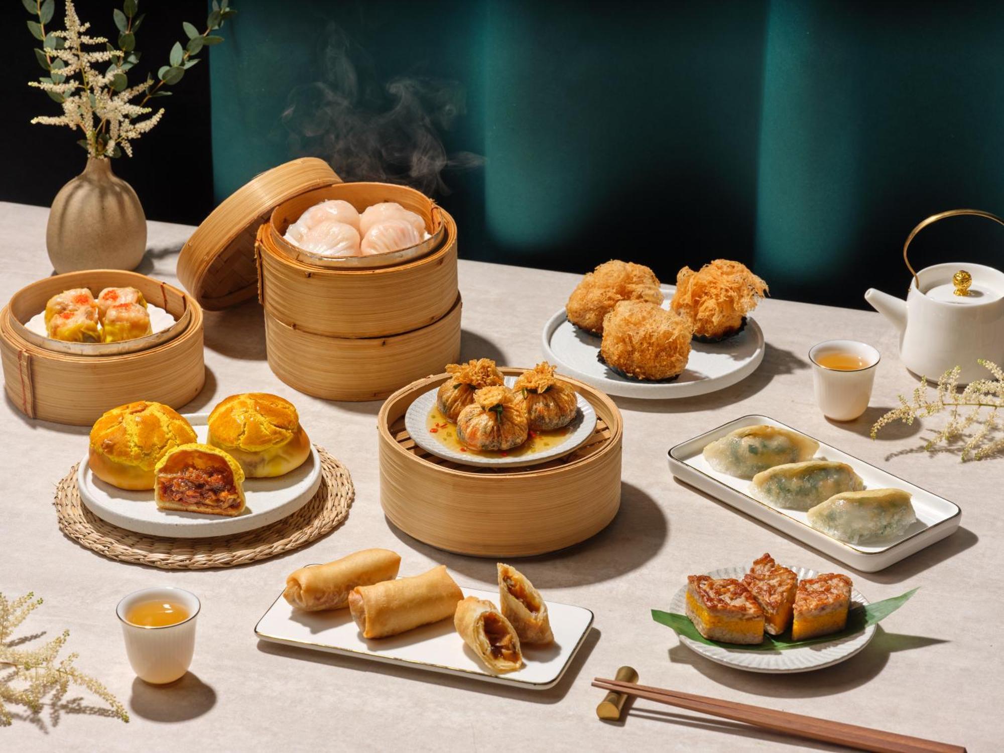 新加坡卡尔登酒店【Sg清洁认证】 外观 照片 The photo displays a delightful spread of various Asian dim sum dishes. 

1. **Steamed buns** in bamboo steamers, likely filled with ingredients such as pork or chicken.
2. **Fried items** like spring rolls and possibly prawn balls, which are golden 